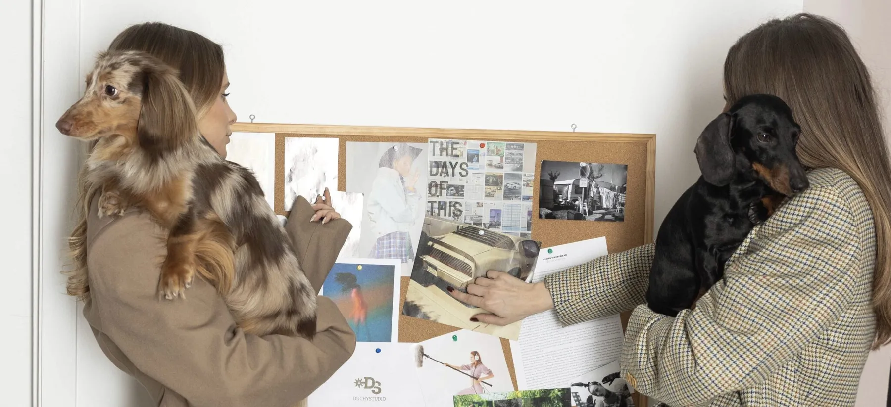 Marta e Federica in studio con i loro due bassotti davanti alla moodboard