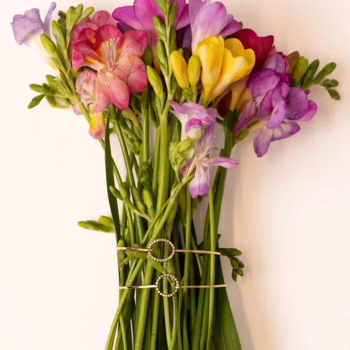 Bouquet di fresie legato con un bracciale dorato